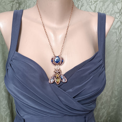 Blue winged bee pollinating on a flower. Pin/pendant.