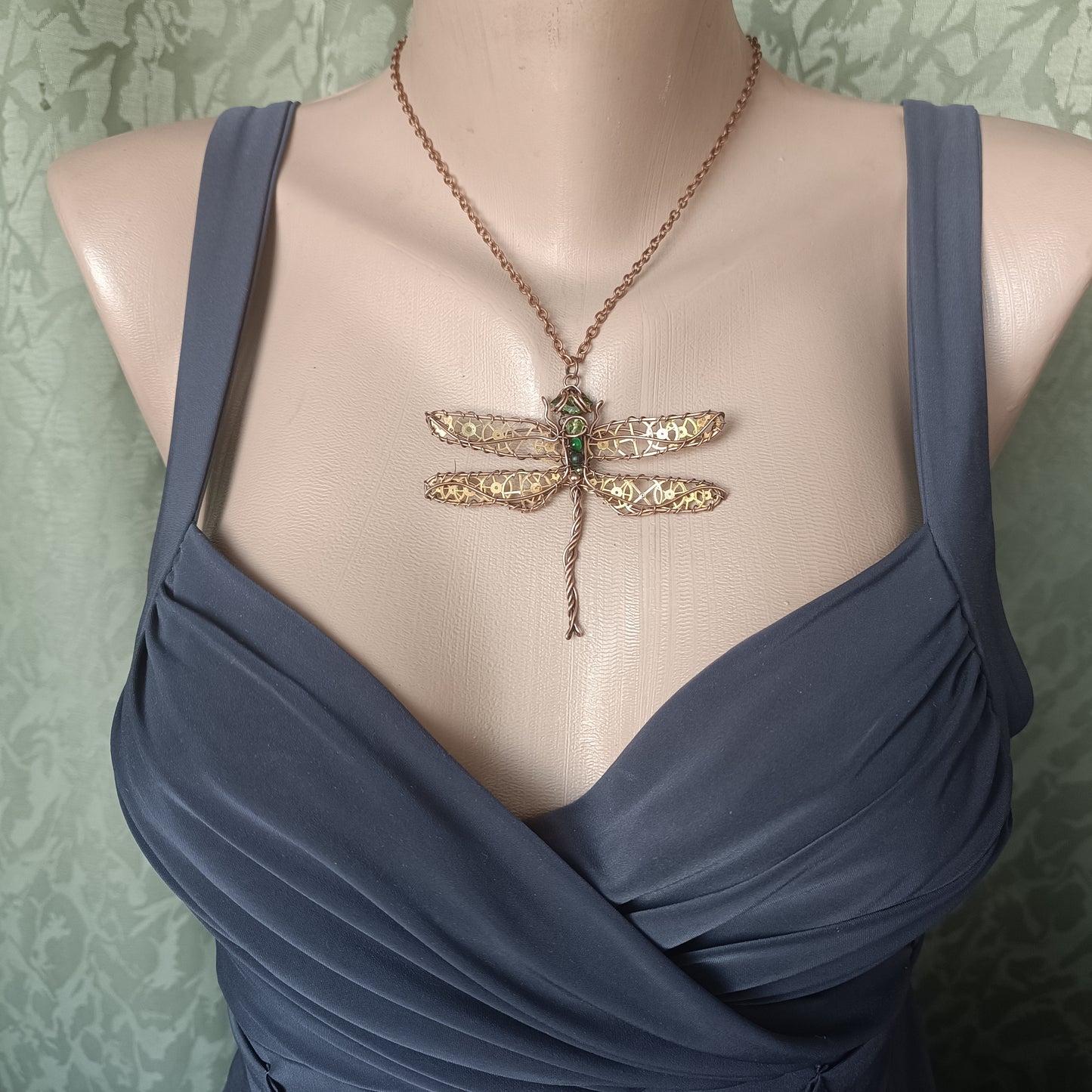 Large green dragonfly with golden cogs.
