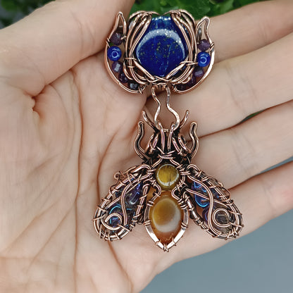 Blue winged bee pollinating on a flower. Pin/pendant.