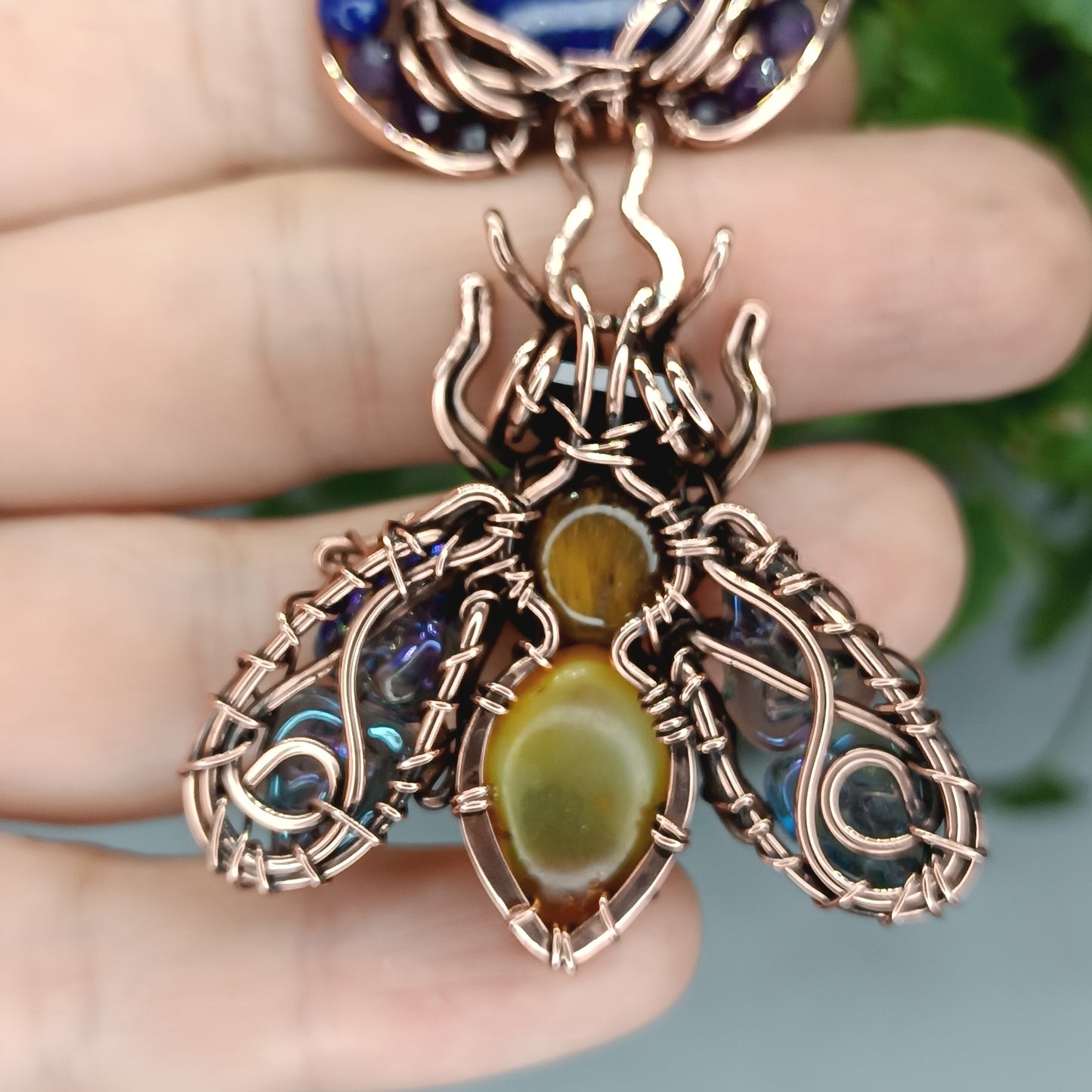 Blue winged bee pollinating on a flower. Pin/pendant.